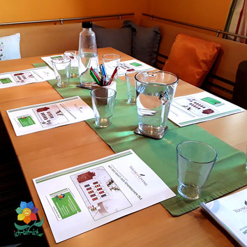 Gedeckter Tisch mit Wassergläsern und Schulungsunterlagen