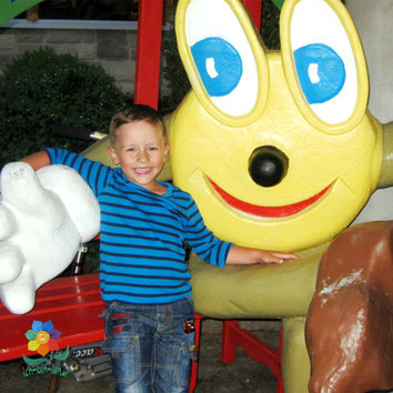 Kleiner Junge umarmt Figur eines Riesensmileys