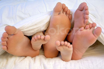 Füße der schlafenden Familie unter schlafdecke
