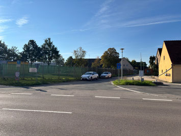 Parkmöglichkeiten am Straßenrand & gegenüberliegender Fläche vor gelber Hauswand