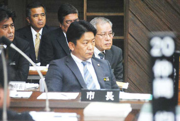 バーベキュー大会のパチンコ業者協賛をめぐり、前津氏の質問を厳しい表情で聞く中山市長と部長=12日午後、議場