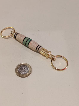 124. Double ended hand turned wood and gilt keyring.