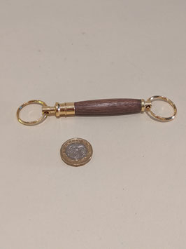 153.  Double ended hardwood and gilt keyring.