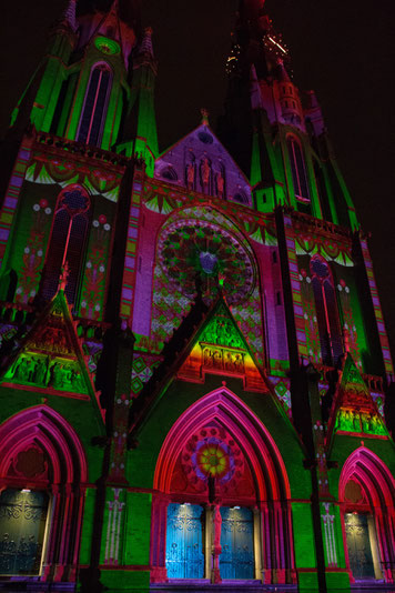 Een kerk met kleurbelichting. Hoofdkleuren rood en groen.