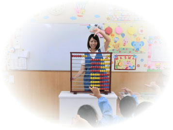 百玉そろばんを子どもたちに指導している保育者
