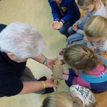 Een vrijwilliger die een baardagame laat zien aan een groep kinderen tijdens een BSO activiteit