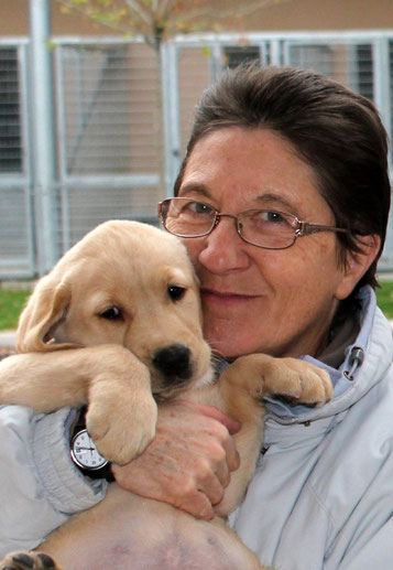 Photo de Martine en gros plan qui tient dans ses bras un chiot labrador très mignon