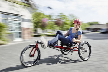 Kettwiesel Allrounder Action - Eine Frau fährt mit einem Hase Bike durch die Straße