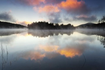 shore reflecting on lake at dusk