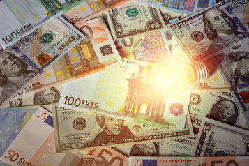 Foto mit Geldscheinen, die von einer Glühbirne beleuchtet sind