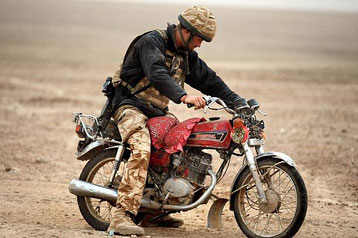 Harry cerca di avviare una motocicletta abbandonata nel deserto. Nella provincia di Helmand, nel sud dell'Afghanistan, 21 febbraio 2008