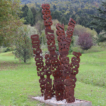 Paolo Grassi – Piera, vertical iron sculpture with numeric pillars emerging from a shared base.