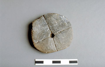 Rondelle de schiste perforée et gravée dont l'usage exact n'est pas formellement avéré (Bronze Ancien)