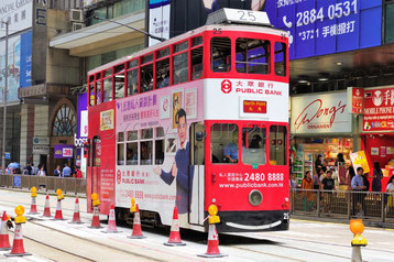 Un tramway rouge circule dans l'Avenue de Nathan Road à Hong Kong