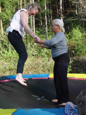 Zwei Frauen spielen auf einem grossen Trampolin mit der elastischen Kraft im Taichi.