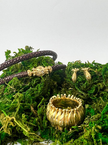 Ein Ring, Lederbracelet und Ohrstecker aus der Zaubergarten Kollektion in Gelbgold