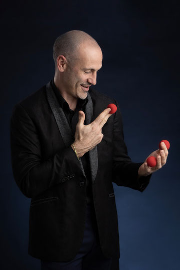 Magicien manipulant des balles en mousse magique rouge