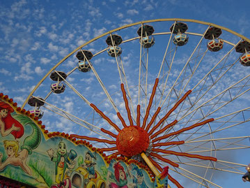 Riesenrad vor blauem Himmel mit Schäfchenwolken 