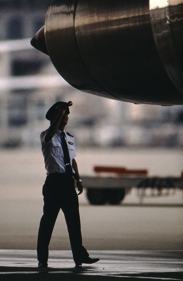 A Japan Air Lines pilot doing his preflight "walkaround" inspection; Narita, Japan.