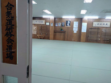 Aikido Kenshukai Dojo's sign is displayed next to an open door with a view of the dojo