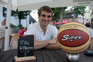 Chris Bengtsson mit Basketball an einem Tisch