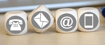 Icons for telephone, post, email and mobile phone on four wooden cubes