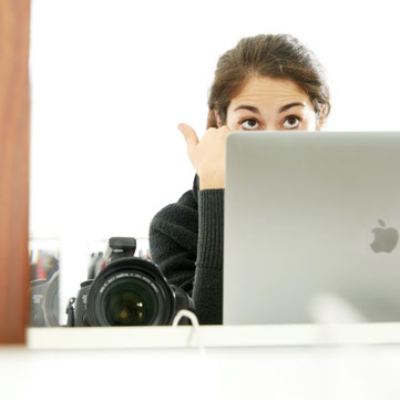 Francesca d'Amico che lavora con un Mac con a fianco una Canon