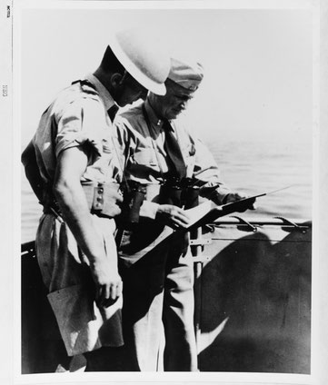 Rear Admiral Lewis, receives a report from a British communications officer, on board USS ANCON (AGC-4), 9 September 1943