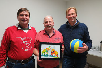 Norbert Terczewski (Mitte) mit einem Bild von Volleyball spielenden Elefanten. Rechts von ihm Heinz Wübbena, links Manfred Wille
