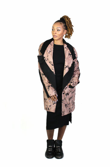 model wearing a black speckled rose coat