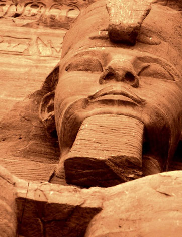 Colossal figures of Ramses II stare down on travelers descending the Nile; Abu Simbel, Egypt.