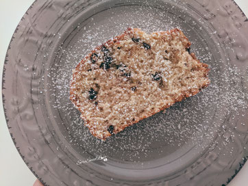 Banana Bread con gocce di cioccolato fondente e spolverata di zucchero a velo servito sul piatto da dessert