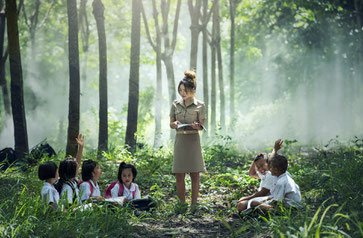 female teacher in front of class in the woods