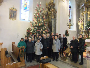 Der derzeit gesamt 22köpfige Kirchenchor Pittersberg zusammen mit Initiator Pfarrer Josef Fromm (2.von rechts) und Chorleiterin Karin Hottner (rechts) unter dem Weihnachtsbaum am Christtag 2017 in der Nikolauskirche nach der gesungenen Messe
