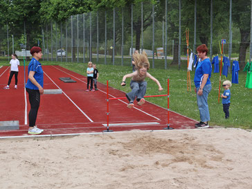 Kinder auf dem Sportgelände beim Weitsprungtraining | has-shadow