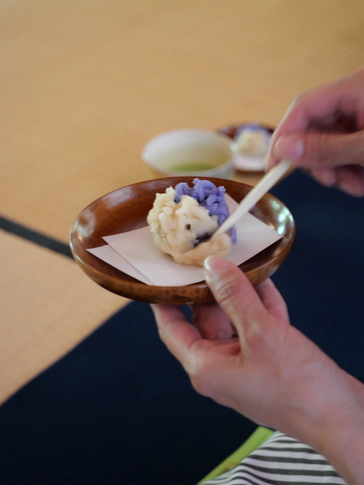 兼六園内にある茶室にて紫色と白色の和菓子に楊枝をさしています。