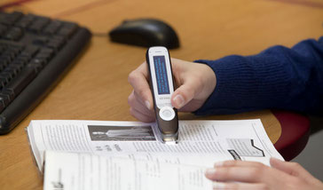 Hand hält einen LingoPen (Vorlesestift) über ein aufgeschlagenes Buch und scannt Text