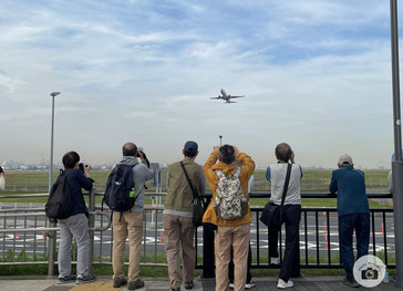 ソラムナード羽田緑地のテラスから飛行機を撮影する会員