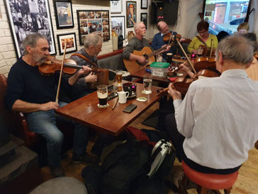 Traditionelle Irische Folk Music von einer Gruppe von Musikern, die um ein paar Tische herum sitzen mit Biergläsern vor sich, in einem Pub ©My own Travel