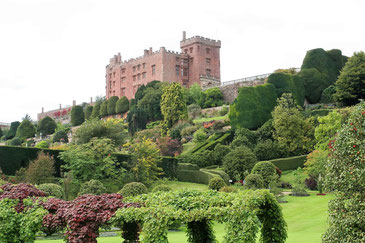 Powis Castle auf einem Hügel mit weitläufigen Gartenanlagen im Vorgergrund