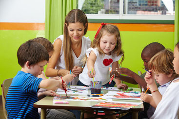 Erzieherin mit Kindern in einer Grundschule oder Kindertagesstätte