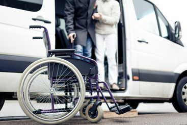 Ein Rollstuhl steht vor dem Transportfahrzeug