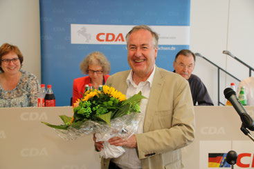 Von Vorne: Dr. Max Matthiesen freut sich nach seiner Widerwahl für zwei Jahre als Vorsitzender, dahiner rechts Tagungspräsident Wolfgang Peter Paul und Präsidiumsmitglied Christine Piefke.