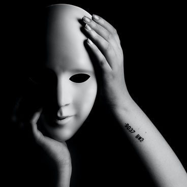 Ein Mensch der sich hinter einer Maske versteckt. So ist es auch mit toxischer Positivität, wenn alle anderen Gefühle unterdrückt werden.