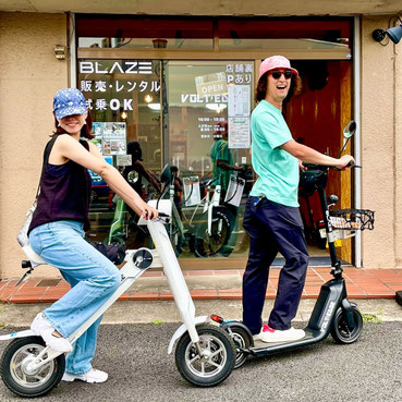 レンタル利用のお客様が店舗前で特定小型原付と記念撮影している様子