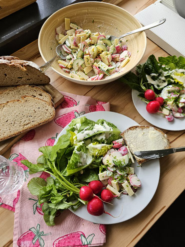 Radieschen-Käse-Salat mit frischem Bauernbrot auf einem gedeckten Tisch 