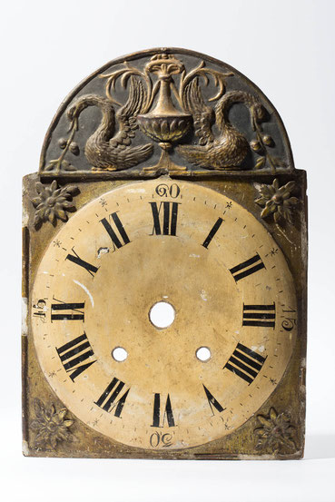 Vergoldetes Uhrenschild einer schwarzwälder Uhr. vor der Restaurierung mit Streiflcht fotogrfiert. 