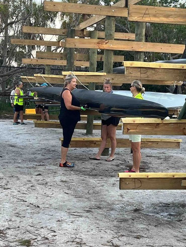 several rowers shown next to several sweep rowing shells
