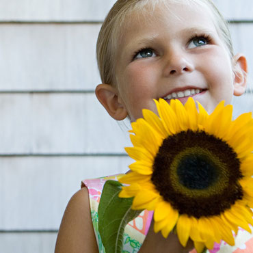 Kind mit Sonneblume und Heuschnupfen Allergie