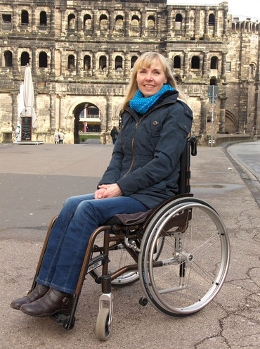 Melli im Rollstuhl vor der Porta Nigra / Melli in her wheelchair in front of the Porta Nigra